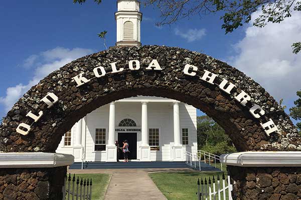 Stone arch reading “Koloa Church” in front of the historic church entrance on Kauai.